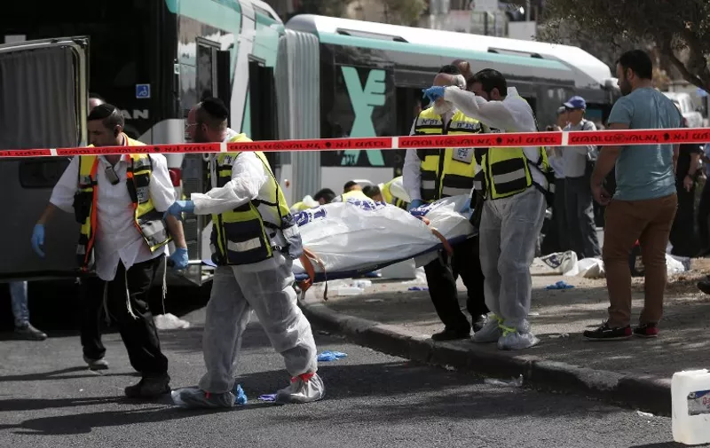 Israeli Zaka volunteers carry a body following a shooting attack on a bus in an east Jerusalem Jewish settlement adjacent to the Palestinian neighbourhood of Jabal Mukaber on October 13, 2015. Two attackers opened fire on a bus while another assailant carried out a car and knife assault in Jerusalem, leaving two people dead and five wounded in two separate incidents, Israeli authorities said. AFP PHOTO / THOMAS COEX