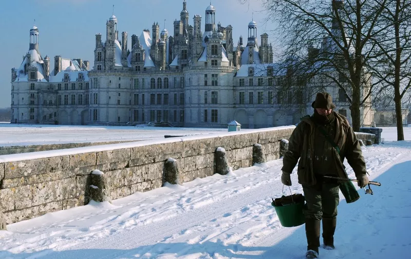 A fisherman walks in the snow near the Chambord castle, on January 6, 2009 in Chambord, western France. Temperatures are expected to fall next days minus 5 to minus 10 degrees Celsius. Northern, central and western France were hit by snow and freezing rain during Monday, causing accidents, one fatal. Weather services warned that the thermometer would fall further during the week as icy air arrived from Siberia and Scandinavia. AFP PHOTO ALAIN JOCARD (Photo by ALAIN JOCARD / AFP)