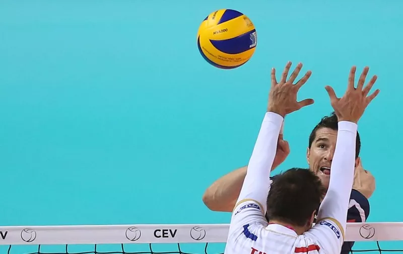 Croatia's Igor Omrcen hits a return against France's Kevin Tillie during the Pool B match between Croatia and France at the European Volleyball Championships in Turin on October 9, 2015.  AFP PHOTO / MARCO BERTORELLO