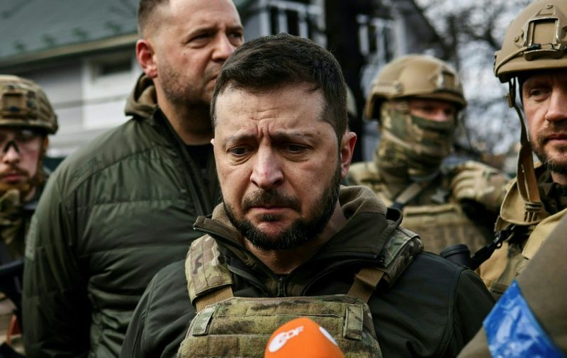 Ukrainian President Volodymyr Zelensky (C) speaks to media in the town of Bucha, northwest of the Ukrainian capital Kyiv, on April 4, 2022. - Ukraine's President Volodymyr Zelensky said on April 3, 2022 the Russian leadership was responsible for civilian killings in Bucha, outside Kyiv, where bodies were found lying in the street after the town was retaken by the Ukrainian army. (Photo by RONALDO SCHEMIDT / AFP)