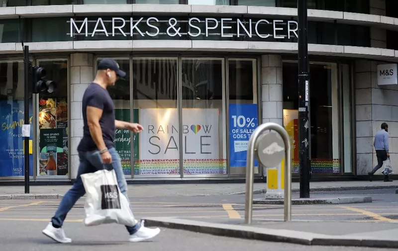 A pedestrian walks past an M&amp;S (Marks and Spencer) store in central London on July 20, 2020. British clothing-to-food retailer Marks &amp; Spencer could axe up to 950 management and administrative jobs to counter slumping profits and sales in the face of the coronavirus outbreak, it said Monday. The high-street stalwart, which had already been suffering from fierce online competition from the likes of US giant Amazon, has seen its troubles compounded by the COVID-19 lockdown that shuttered shops nationwide. (Photo by Tolga AKMEN / AFP)