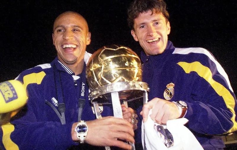 Brazilian Roberto Carlos (L)  and teammate Croatian Davor Suker of Real Madrid hold  the trophy at their arrival in Madrid  02 December. Real Madrid club won in Tokyo the Intercontinental Cup, with a  2-1 victory over the Brazilian club of Vasco de Gama.  (ELECTRONIC IMAGE)