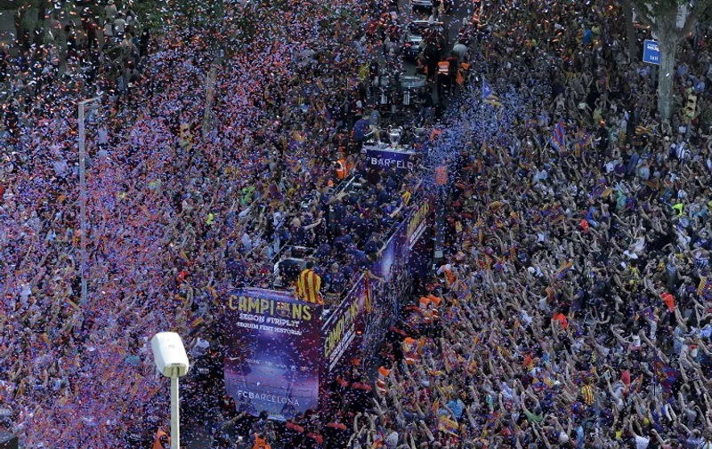 FC Barcelona players parade on a bus through the streets of Barcelona as they celebrate their victory over Juventus one day after the UEFA Champions League final football on June 7, 2015. Luis Suarez and Neymar scored second-half goals to give Barcelona a 3-1 Champions League final victory over Juventus on June 6, 2015 as the Spaniards became the first team to twice win the European treble.   AFP PHOTO/ JOSEP LAGO