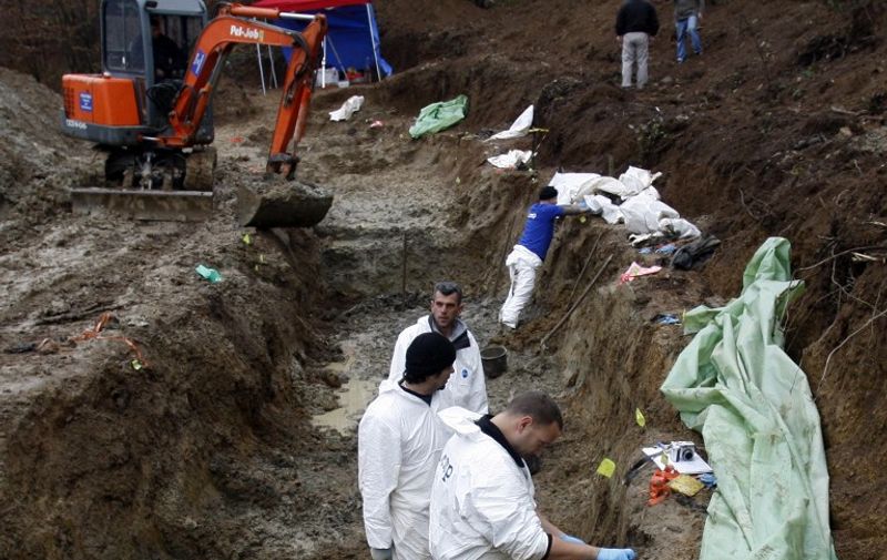 Bosnian forensic experts members of the International Commission for Missing Persons ICMP search for human remains at a mass-grave site in the remote mountain area in the village of Zalazje near the eastern-Bosnian town of Srebrenica, on December 3, 2009. Forensic experts started exhuming the 80th mass grave that contains remains of the Bosnian muslims civilians killed in the 1995 Srebrenica massacre. AFP PHOTO STR / AFP / STR