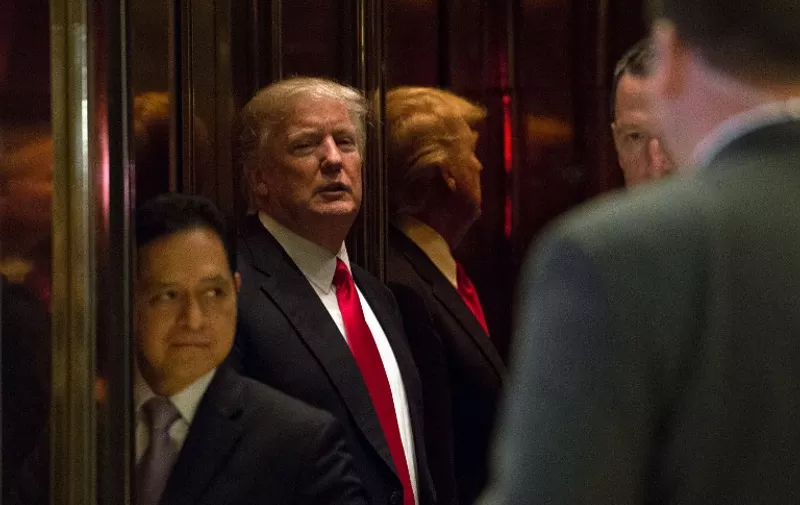 President-elect Donald Trump is seen in the elevator after speaking with the media at Trump Tower on January 13, 2017 in New York. / AFP PHOTO / Bryan R. Smith