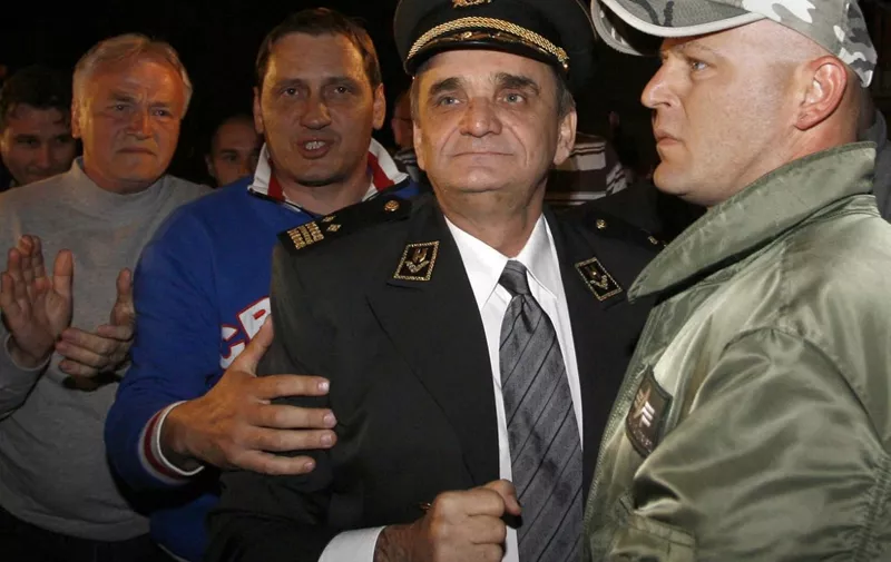 Retired Croatian General and parliament member Branimir Glavas (C) is surrounded by supporters as he is about to enter prison in the eastern Croatian town of Osijek as he voluntarily surrenders to Croatian police, 17 April 2007. Croatian prosecutors indicted 16 April 2007 the former deputy and six others for killing Serb civilians in the eastern town of Osijek during the country's independence war. Glavas, 50, was charged with ordering the 1991 abductions, torture and murder of 10 Serbs who were killed by a special unit formed by co-accused Ivica Krnjak and Gordana Getos Magdic, said the indictment. Glavas is the most senior political figure to have faced legal action for war crimes in Croatia.   AFP PHOTO/STR (Photo by STRINGER / AFP)