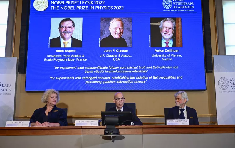 Secretary General of the Royal Swedish Academy of Sciences Hans Ellegren (C), Eva Olsson (L) and Thors Hans Hansson (R), members of the Nobel Committee for Physics announce the winners of the 2022 Nobel Prize in Physics (L-R on the screen)  Alain Aspect, John F. Clauser and Anton Zeilinger, during a press conference at The Royal Swedish Academy of Sciences in Stockholm, Sweden, on October 4, 2022.
Photo: Jonas Ekstromer / TT / code 10030 (Photo by JONAS EKSTROMER / TT NEWS AGENCY / TT News Agency via AFP)