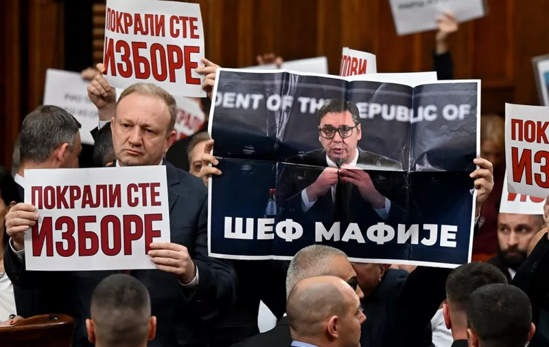 Opposition MP Dragan Djilas (L) holds a placard reading "You stole the elections" next to a poster depicting Serbian President Aleksandar Vucic with the text "Mafia chief", during the first session of the new National Assembly in Belgrade on February 6, 2024. Serbia's Parliament was set to convene its first session on February 6, weeks after contested elections were hit by allegations of electoral fraud. The Balkan nation's electoral commission said President Aleksandar Vucics ruling Serbian Progressive Party (SNS) had secured a commanding victory by winning 46.75 percent in the parliamentary vote. The main opposition camp -- known as the Serbia Against Violence (SPN) coalition -- received just 23.66 percent. (Photo by Andrej ISAKOVIC / AFP)