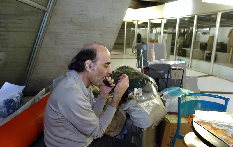 (FILES) In this file photo taken on August 12, 2004 Mehran Karimi Nasseri shaves, early in the morning, in the terminal 1 of Paris Charles De Gaulle airport. - Mehran Karimi Nasseri, a political refugee who lived over 18 years in Paris' Roissy-Charles de Gaulle airport and inspired director Steven Spielberg's "The Terminal", died, aged 77, at Roissy-Charles de Gaulle airport's terminal 2F, as reported to AFP by airport officials. (Photo by STEPHANE DE SAKUTIN / AFP)