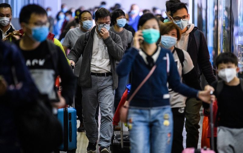 Passengers wear protective face masks as they arrive from Shenzhen to Hong Kong at Lo Wu MTR station, hours before the closing of the Lo Wu border crossing in Hong Kong, on February 3, 2020, amid an outbreak of a deadly SARS-like virus which began in the Chinese city of Wuhan. - Hong Kong announced it was closing all but two land crossings with the Chinese mainland on February 3 to slow the spread of a deadly new coronavirus as medics staged strikes calling for the border to be completely sealed. (Photo by Anthony WALLACE / AFP)