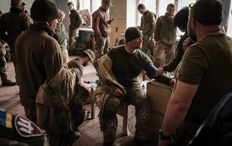 Ukrainian soldiers receive medical treatment as they arrive at an abandoned building to rest after fighting on the front line for two months near Kramatorsk, eastern Ukraine on April 30, 2022. - Russia invaded Ukraine on February 24, 2022. (Photo by Yasuyoshi CHIBA / AFP)