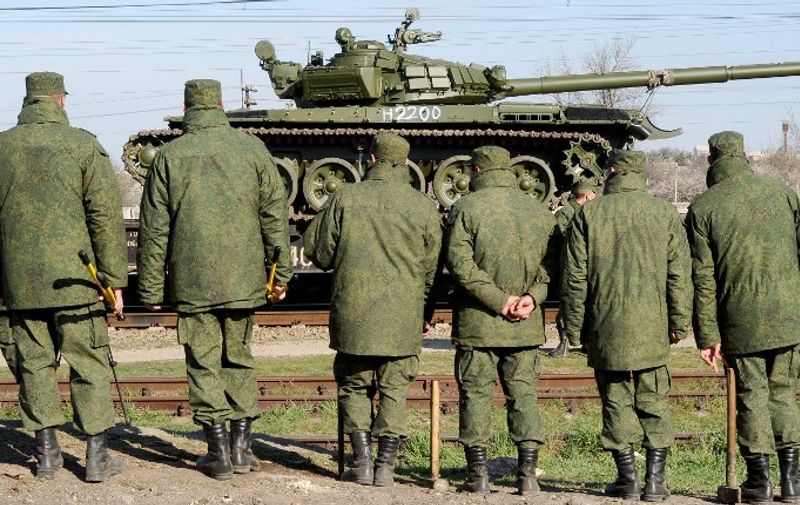 Russian soldiers unload trainload of their modified T-72 tanks after their arrival in Gvardeyskoe railway station near the Crimean capital Simferopol, on March 31, 2014. The Crimean crisis has sparked the most explosive East-West confrontation since the Cold War and fanned fears in Kiev that Russian President Vladimir Putin now intends to push his troops into southeast Ukraine.  AFP PHOTO / OLGA MALTSEVA / AFP / OLGA MALTSEVA