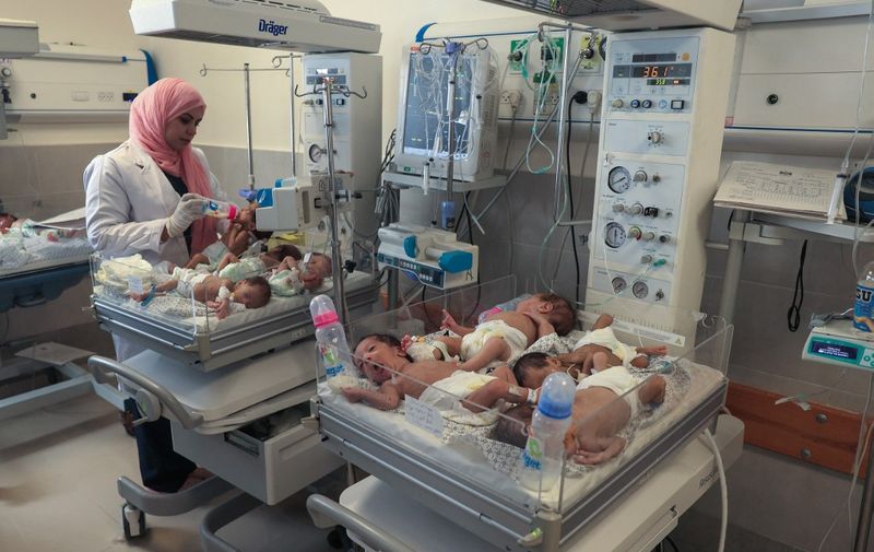 A Palestinian medic cares for premature babies, evacuated from Gaza City's Al Shifa hospital, ahead of their transfer from a hospital in Rafah in the southern Gaza Strip to Egypt, on November 20, 2023, amid ongoing battles between Israel and the militant group Hamas. Twenty-nine premature babies arrived in Egypt on November 20, Egyptian media said, after their evacuation from Gaza's largest hospital which has become a focal point of Israel's war with Hamas. (Photo by SAID KHATIB / AFP) / The erroneous DATE appearing in the metadata of this photo by SAID KHATIB has been modified in AFP systems in the following manner: [November 20] instead of [November 19]. Please immediately remove the erroneous mention[s] from all your online services and delete it (them) from your servers. If you have been authorized by AFP to distribute it (them) to third parties, please ensure that the same actions are carried out by them. Failure to promptly comply with these instructions will entail liability on your part for any continued or post notification usage. Therefore we thank you very much for all your attention and prompt action. We are sorry for the inconvenience this notification may cause and remain at your disposal for any further information you may require.