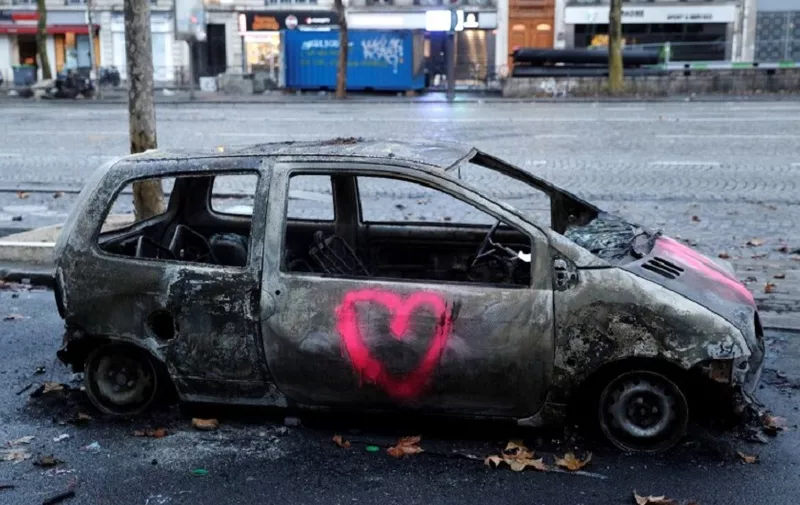 A picture shows a burned car in a street of Paris on December 2, 2018, a day after clashes during a protest of Yellow vests (Gilets jaunes) against rising oil prices and living costs. - Anti-government protesters torched dozens of cars and set fire to storefronts during daylong clashes with riot police across central Paris on N, as thousands took part in fresh "yellow vest" protests against high fuel taxes. (Photo by Geoffroy VAN DER HASSELT / AFP)