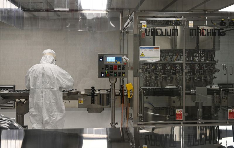 A laboratory technician takes part in filling and packaging tests for the large-scale production and supply of the University of Oxfords COVID-19 vaccine candidate, AZD1222, conducted on a high-performance aseptic vial filling line on September 11, 2020 at the Italian biologics manufacturing facility of multinational corporation Catalent in Anagni, southeast of Rome, during the COVID-19 infection, caused by the novel coronavirus. - Catalent Biologics manufacturing facility in Anagni, Italy will serve as the launch facility for the large-scale production and supply of the University of Oxfords Covid-19 vaccine candidate, AZD1222, providing large-scale vial filling and packaging to British-Swedish multinational pharmaceutical and biopharmaceutical company AstraZeneca. (Photo by Vincenzo PINTO / AFP)