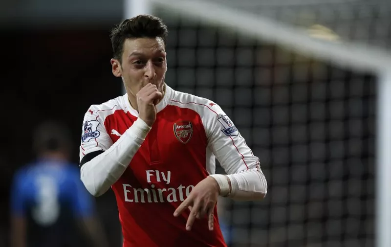 Arsenal's German midfielder Mesut Ozil celebrates after scoring their second goal during the English Premier League football match between Arsenal and Bournemouth at the Emirates Stadium in London on December 28, 2015. AFP PHOTO / ADRIAN DENNIS

RESTRICTED TO EDITORIAL USE. No use with unauthorized audio, video, data, fixture lists, club/league logos or 'live' services. Online in-match use limited to 75 images, no video emulation. No use in betting, games or single club/league/player publications. / AFP / ADRIAN DENNIS