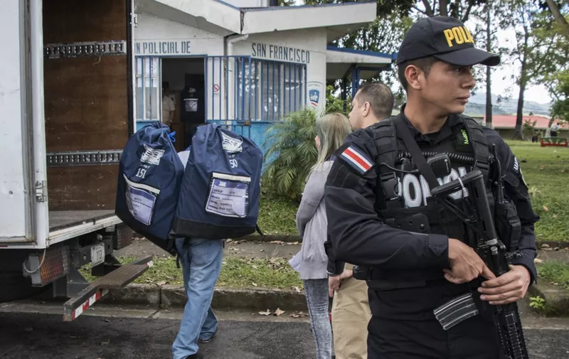 A police officer provides security as electoral material is delivered to a police station in the neighbourhood of San Francisco, San Jose, on January 19, 2018. - Costa Rica will hold the first round of presidential and legislative elections on February 4. (Photo by Ezequiel BECERRA / AFP)