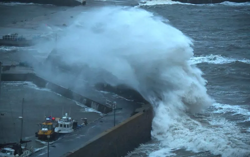 Waves crash over Stonehaven harbour on the east coast of Scotland on October 19, 2023, as wind and rain from Storm Babet cause travel chaos. (Photo by ANDY BUCHANAN / AFP)