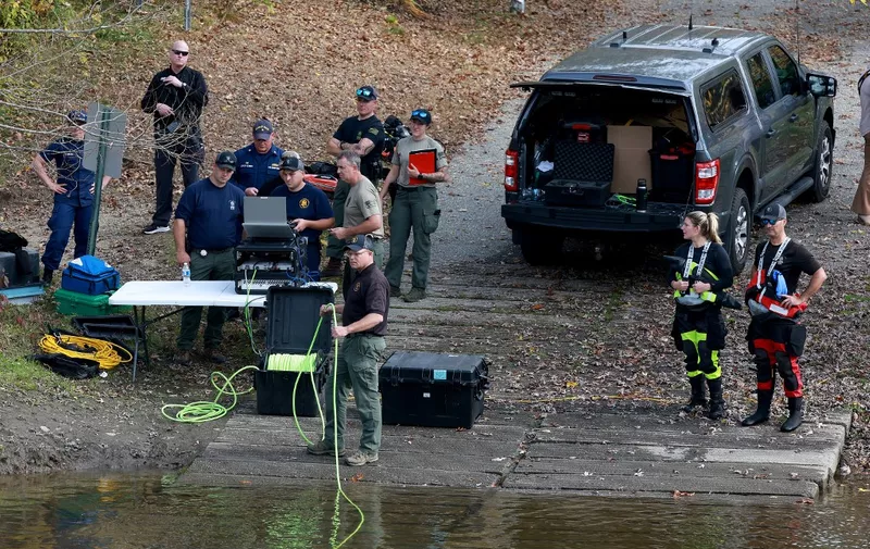 LISBON, MAINE - OCTOBER 27: Law enforcement officers use an underwater robotic camera to search the water around the Pejepscot Boat Ramp on the Androscoggin River where the suspect being searched for in connection with two mass shootings abandoned his vehicle on October 27, 2023 in Lisbon, Maine. Police are actively searching for a suspect, Army reservist Robert Card, who allegedly killed 18 people in a mass shooting at a bowling alley and restaurant in Lewiston, Maine.   Joe Raedle/Getty Images/AFP (Photo by JOE RAEDLE / GETTY IMAGES NORTH AMERICA / Getty Images via AFP)