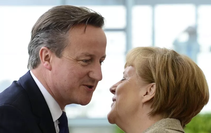 German Chancellor Angela Merkel (R) kisses British Prime Minister David Cameron upon his arrival for a meeting on May 29, 2015, at the Chancellery in Berlin. Cameron is on a two-day tour of European capitals in a bid to secure EU reforms as his government published a law paving the way for a vote on whether Britain should leave. AFP PHOTO / JOHN MACDOUGALL