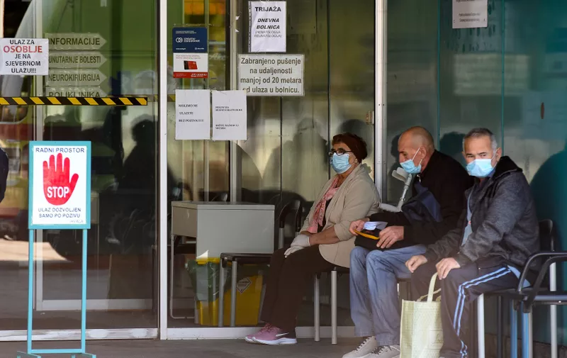 People wearing face masks wait to be admitted to the Dubrava Clinical  Hospital in Zagreb on October 19, 2020, amid the Covid-19 pandemic, caused by the novel coronavirus. Croatia has seen a surge in coronavirus infections and authorities have expressed concern over the lack of capacity in the country's overloaded hospitals. A large number of hospital staff have been infected or are in self-isolation.,Image: 564476272, License: Rights-managed, Restrictions: , Model Release: no