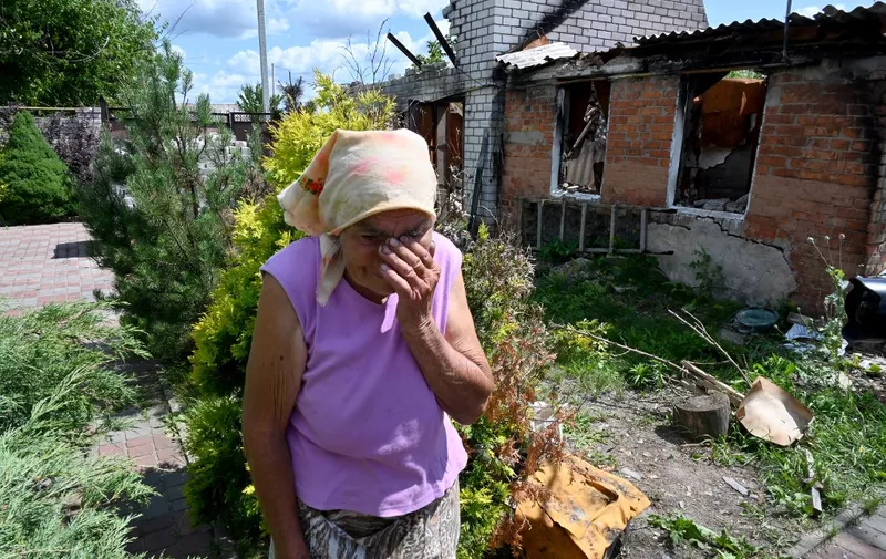 Local resident Maria Laptykova, 87, reacts as she walks outside her house destroyed by Russian shelling in the village of Borshchova, Kharkiv region, on July 19, 2023, amid Russian invasion of Ukraine. (Photo by SERGEY BOBOK / AFP)