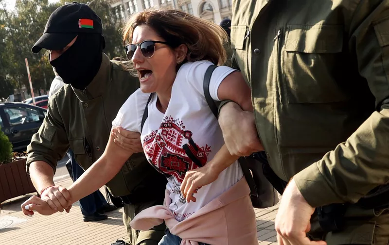 Law enforcement officers detain a woman during an opposition rally to protest against the presidential inauguration in Minsk on September 26, 2020. - Belarus leader Alexander Lukashenko held his presidential inauguration in secret on September 23, 2020, after claiming victory in disputed polls that his opposition rivals have described as massively rigged. (Photo by STRINGER / AFP)