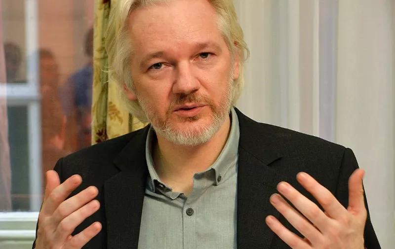 WikiLeaks founder Julian Assange gestures during a press conference inside the Ecuadorian Embassy in London on August 18, 2014 where Assange has been holed up for two years. WikiLeaks founder Julian Assange said Monday he would "soon" leave Ecuador's embassy in London but his organisation played down the comment, saying he would not depart until there was an agreement with Britain's government.  Assange took refuge in June 2012 in the Ecadorian Embassy to avoid extradition to Sweden, where he faces allegations of rape and sexual molestation, which he strongly denies.  AFP PHOTO / POOL / JOHN STILLWELL / AFP / POOL / JOHN STILLWELL