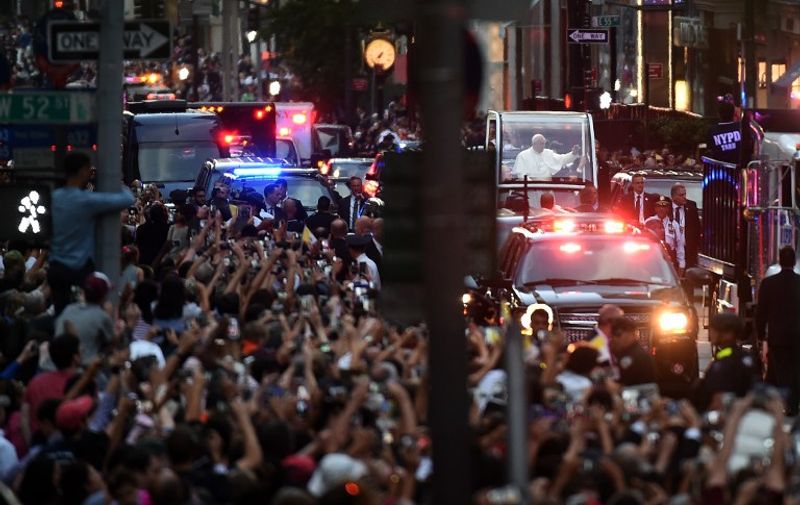 Pope Francis waves as he approaches St. Patrick's Cathedral to lead evening prayers in New York on September 24, 2015. Pope Francis arrived in New York on the second leg of his US tour where he will address the UN General Assembly, visit the 9/11 Memorial and celebrate mass at Madison Square Garden. AFP PHOTO/JEWEL SAMAD