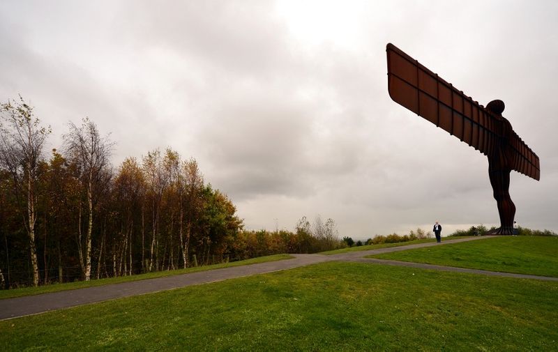 The Angel of The North sculpture stands near autumn coloured trees near Gateshead, northeast England, on October 29, 2012. British sculptor Antony Gormley's creation stands 20 metres tall and has a winspan of 54 metres across. AFP PHOTO/PAUL ELLIS (Photo by PAUL ELLIS / AFP)