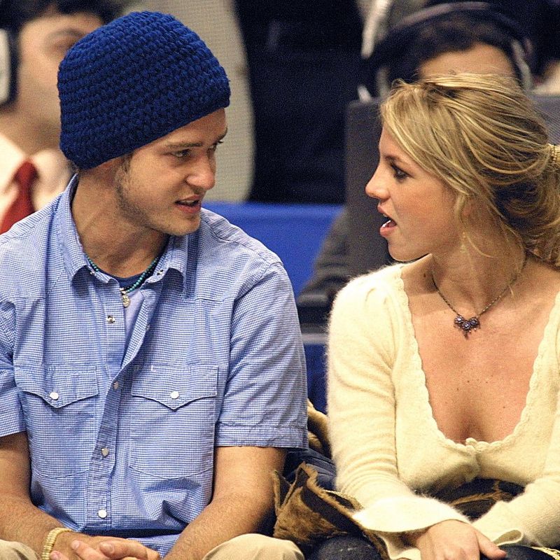 Pop superstars Britney Spears (R) and boyfriend Justin Timberlake (L) talk as they sit courtside at the NBA All-Star Game 10 February 2002 in Philadelphia.  AFP Photo / Tom Mihalek (Photo by TOM MIHALEK / AFP)
