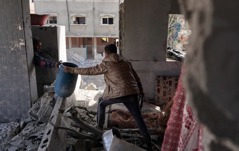 Members of the Abul Aoun family salvage some belongings from the rubble in their home destroyed during Israeli bombardment on the Al-Maghazi refugee camp in Deir Balah in the central Gaza Strip on March 31, 2024, amid the ongoing conflict between Israel and the Hamas militant group. (Photo by AFP)