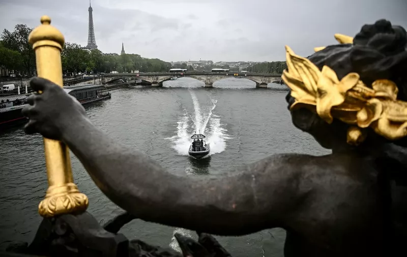 Members of the French police's River Brigade (Brigade Fluviale) patrol on a boat past the Eiffel tower and under the Alexandre III bridge on the Seine river in Paris on May 9, 2023. (Photo by Christophe ARCHAMBAULT / AFP)