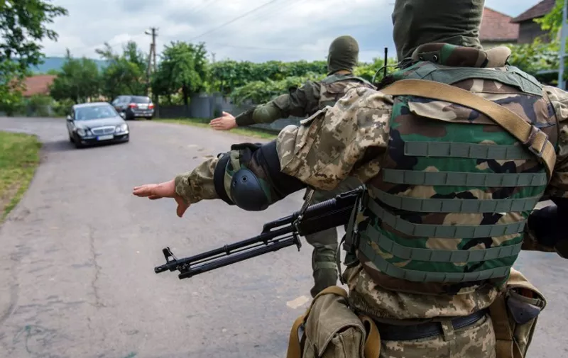 Ukrainian Security forces patrol in the village of Bobrovyshche near the small Ukrainian town of Mukacheve, to locate far-right nationalist organization Pravy Sektor (Right Sector) fighters on July 14, 2015. At least two people were killed and several more injured in fighting that erupted on July 11 between police and heavily armed members of the far-right nationalist organization Pravy Sektor (Right Sector) in Mukacheve, western Ukraine. Ukrainian President Petro Poroshenko confronted a fresh crisis on July 13 as a deadly standoff between interior ministry units and armed Ukrainian ultranationalists entered a third day in a western enclave near Hungary. AFP PHOTO/ ALEXANDER ZOBIN