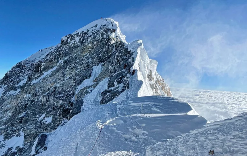 This photograph taken on May 31, 2021 shows mountaineers climbing the Hillary Step during their ascend of the South face to summit Mount Everest (8,848.86-metre), in Nepal. (Photo by Lakpa SHERPA / AFP)