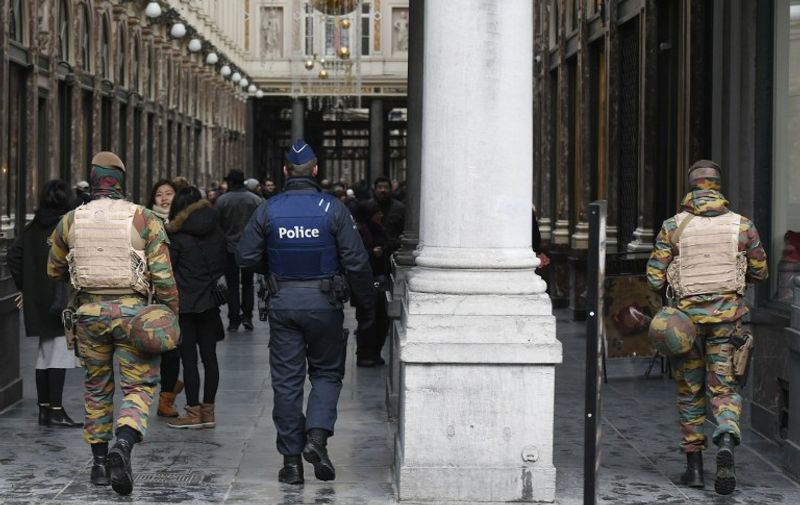 Belgian soldiers and police officers patrol at the entrance of the Galerie de la Reine near the Grand Place in Brussels on November 22, 2015. The Belgian capital was locked down for a second day on November 22 with police and troops on the streets as the authorities hunted for several suspects linked to the Paris attacks. Belgian officials were due to meet later to decide whether to extend the security alert in Brussels, imposed over fears jihadists were plotting similar strikes to the attacks in Paris which left 130 people dead on November 13. AFP PHOTO / JOHN THYS / AFP / JOHN THYS
