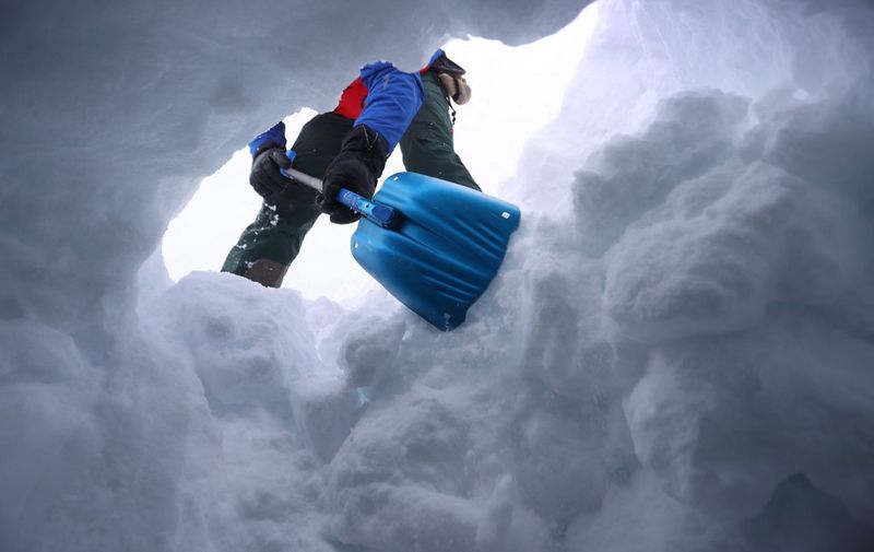 21 January 2022, Bavaria, Obermaiselstein: A member of the mountain rescue team shovels the entrance to a snow hole during the avalanche dog course of the Allgäu mountain rescue team. (to dpa-Korr) Photo: Karl-Josef Hildenbrand/dpa (Photo by KARL-JOSEF HILDENBRAND / DPA / dpa Picture-Alliance via AFP)