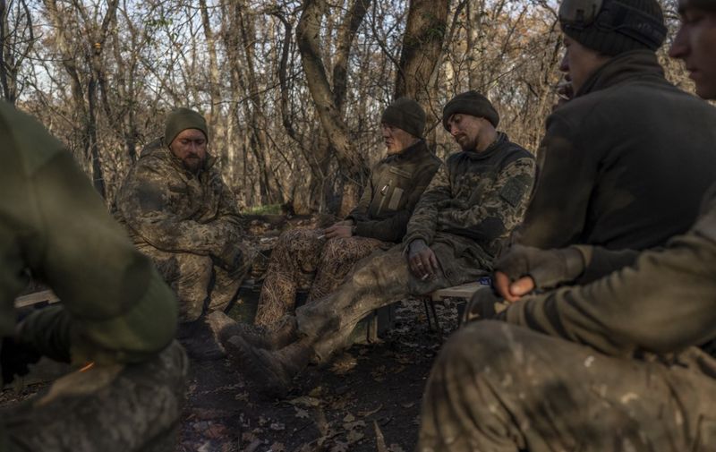 Ukrainian soldiers of an artillery unit have a rest outside Bakhmut on November 8, 2022, amid the Russian invasion of Ukraine. (Photo by BULENT KILIC / AFP)