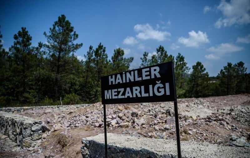 A sign reading in Turkish  "Traitors' Cemetery" is seen in front of unmarked graves built specially by Istanbul municitality for the dead failed coup soldiers, on July 28,2016 at Pendik district in Istanbul.
 Turkey's top military commanders met Thursday to replace almost half of their generals in a radical shake-up after the failed coup, as authorities shut down dozens of media outlets in a widening crackdown. / AFP PHOTO / OZAN KOSE