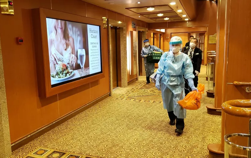 This handout photo released to AFP via Twitter handle @DAXA_TW on February 4, 2020 shows officials in masks and protective clothing on one of the decks of the Diamond Princess cruise ship, as the vessel carrying 3,711 people sits in the port of Yokohama. - At least 10 people on the cruise ship quarantined off the coast of Japan have tested positive for the new coronavirus, Japan's health minister said on February 5. (Photo by Handout / Twitter handle @DAXA_TW / AFP) / EDITORS NOTE: THE FACES HAVE BEEN PIXELATED DUE TO SOURCE
-----EDITORS NOTE --- RESTRICTED TO EDITORIAL USE - MANDATORY CREDIT "AFP PHOTO / Twitter handle @DAXA_TW" - NO MARKETING - NO ADVERTISING CAMPAIGNS - DISTRIBUTED AS A SERVICE TO CLIENTS  - NO ARCHIVES /