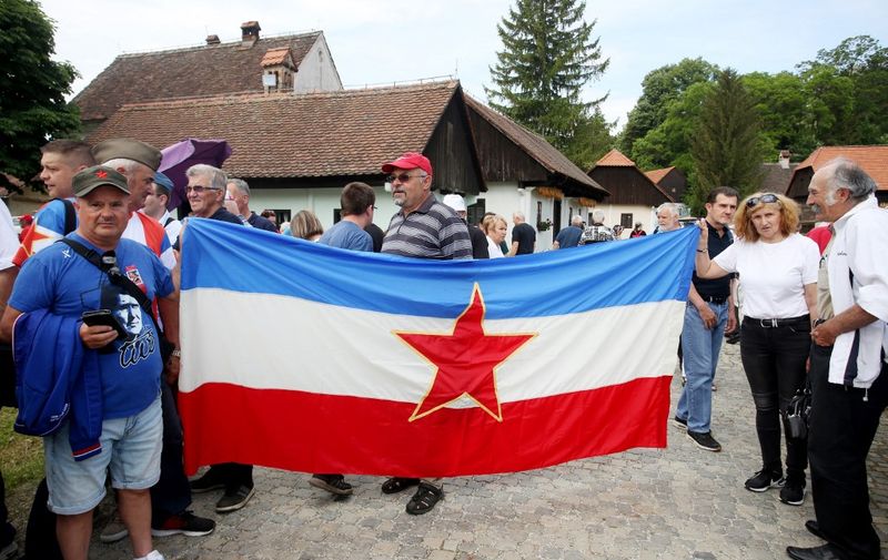 Supporters hold the former Yugoslavia flag during a commemorative rally to mark the 130th anniversary of former leader Josip Broz Tito's birth at his birthplace in northern Croatia in the village of Kumrovec on May 21, 2022. (Photo by Denis LOVROVIC / AFP)