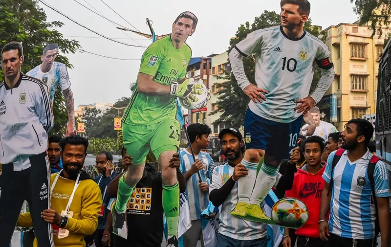 Soccer fans display life-size cut out of Argentinas football team players during a rally to celebrate their win in the Qatar 2022 World Cup final football match between Argentina and France, in Kolkata on December 22, 2022. (Photo by DIBYANGSHU SARKAR / AFP)