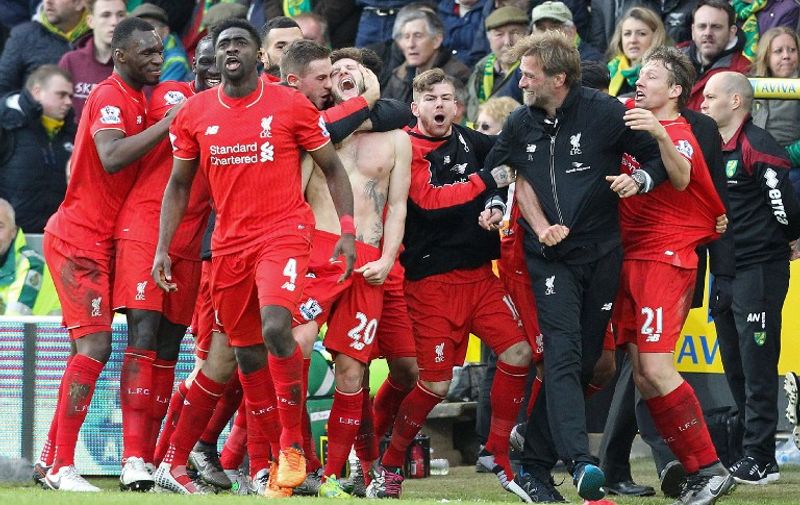 With his shirt off, Liverpool's English midfielder Adam Lallana (C) celebrates scoring their late winning goal with teammates and Liverpool's German manager Jurgen Klopp (3rd R), as Norwich City's Scottish coach Alex Neil (R) looks on during the English Premier League football match between Norwich City and Liverpool at Carrow Road in Norwich, eastern England, on January 23, 2016. Liverpool won the game 5-4. AFP PHOTO / LINDSEY PARNABY

RESTRICTED TO EDITORIAL USE. No use with unauthorized audio, video, data, fixture lists, club/league logos or 'live' services. Online in-match use limited to 75 images, no video emulation. No use in betting, games or single club/league/player publications. / AFP / LINDSEY PARNABY