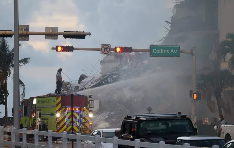 SURFSIDE, FLORIDA - JUNE 25: Miami-Dade Fire Rescue personnel spray water on a fire in the partially collapsed 12-story Champlain Towers South condo building as search and rescue operations continue on June 25, 2021 in Surfside, Florida. 99 people are being reported as missing as search-and-rescue efforts continue with rescue crews from across Miami-Dade and Broward counties.   Joe Raedle/Getty Images/AFP (Photo by JOE RAEDLE / GETTY IMAGES NORTH AMERICA / Getty Images via AFP)