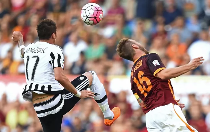 Juventus' forward from Croatia Mario Mandzukic (L) fights for the ball with Roma's midfielder from Italy Daniele De Rossi during the Italian Serie A football match AS Roma vs Juventus on August 30, 2015 at the Olympic stadium in Rome.     AFP PHOTO / FILIPPO MONTEFORTE