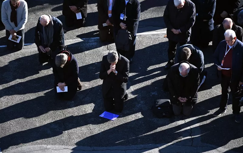 Catholic church bishops kneel as a sign of penance during a ceremony at the sanctuary of Lourdes towards victims of pedocriminality in Lourdes, south-western France on November 6, 2021. - The annual meeting of bishops began on November 2, 2021 in Lourdes where they have a week to reflect on the follow-up to be given to the revelations of the Sauve report, a month after its publication, on the extent of child crime in the Catholic Church. (Photo by Valentine CHAPUIS / AFP)
