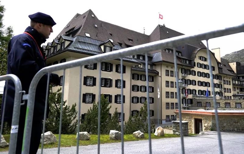 A private policeman guards on June 9, 2011 the Suvretta House five-star hotel in the chic Swiss ski station of St Moritz, where the Bilderberg Group is holding its annual meeting. The secretive Bilderberg Group of some 100 political and economic leaders, as well as aristocrats, is meeting from June 9 to 12 in St Moritz. The group, which has been holding annual off-the record talks open to guests only since 1954, feeds conspiracy theories and speculation about its intentions, with critics accusing it of plotting world domination.   AFP PHOTO / FABRICE COFFRINI