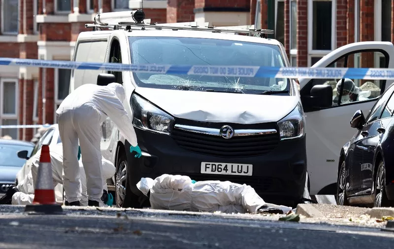 Police forensics officers work around a white van with a shattered windscreen, inside a police cordon on Bentinck Road in Nottingham, central England, following a 'major incident' in which three people were found dead. Police arrested a man Tuesday after three people were found dead and a van tried to mow down three others in the central English city of Nottingham in incidents authorities believe are linked. Nottingham's centre was cordoned off, with a heavy police presence, including some armed officers following the events that left residents shaken. (Photo by Darren Staples / AFP)