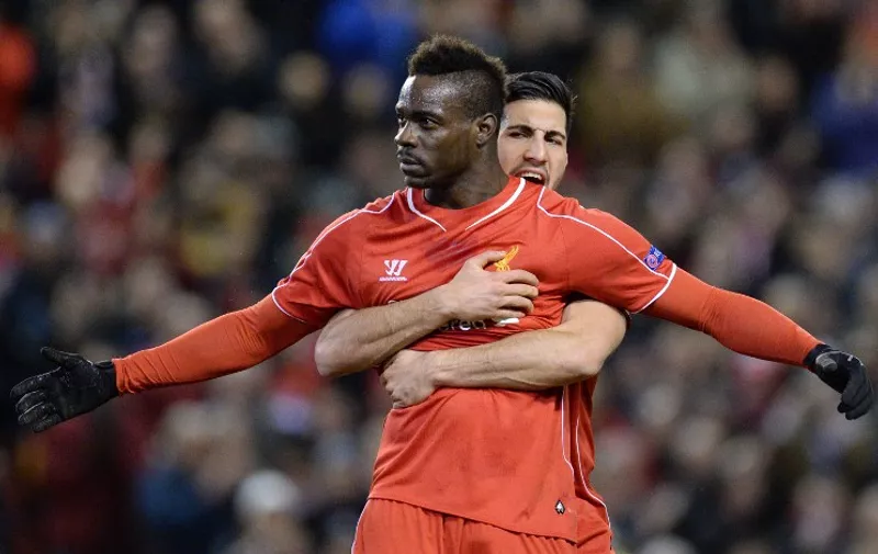 Liverpool's Italian striker Mario Balotelli (front) spreads his arms wide after scoring from the penalty spot for the opening goal as Liverpool's German midfielder Emre Can (back) embraces him from behind during the UEFA Europa League round of 32 first leg football match between Liverpool and Besiktas at Anfield in Liverpool, northwest England, on February 19, 2015.  AFP PHOTO / OLI SCARFF
