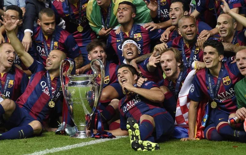 Barcelona's players celebrate with the trophy after the UEFA Champions League Final football match between Juventus and FC Barcelona at the Olympic Stadium in Berlin on June 6, 2015.  FC Barcelona won the match 1-3.   AFP PHOTO / LLUIS GENE